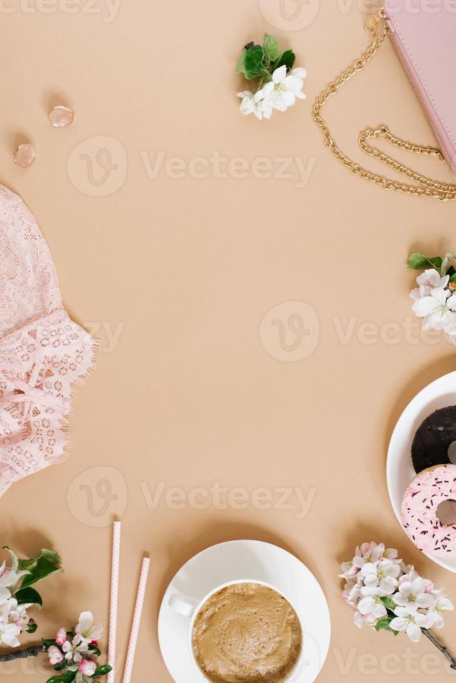 cappuccino beker, donuts, bloemen, roze blouse, handtas Aan beige achtergrond met kopiëren ruimte. modieus elegant vlak leggen mode blogger foto