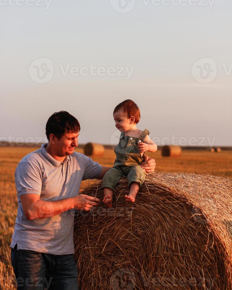 gelukkig vader en zoon hebben pret Aan de veld- Aan een heet zomer dag. concept van vriendelijk familie en van zomer vakantie foto