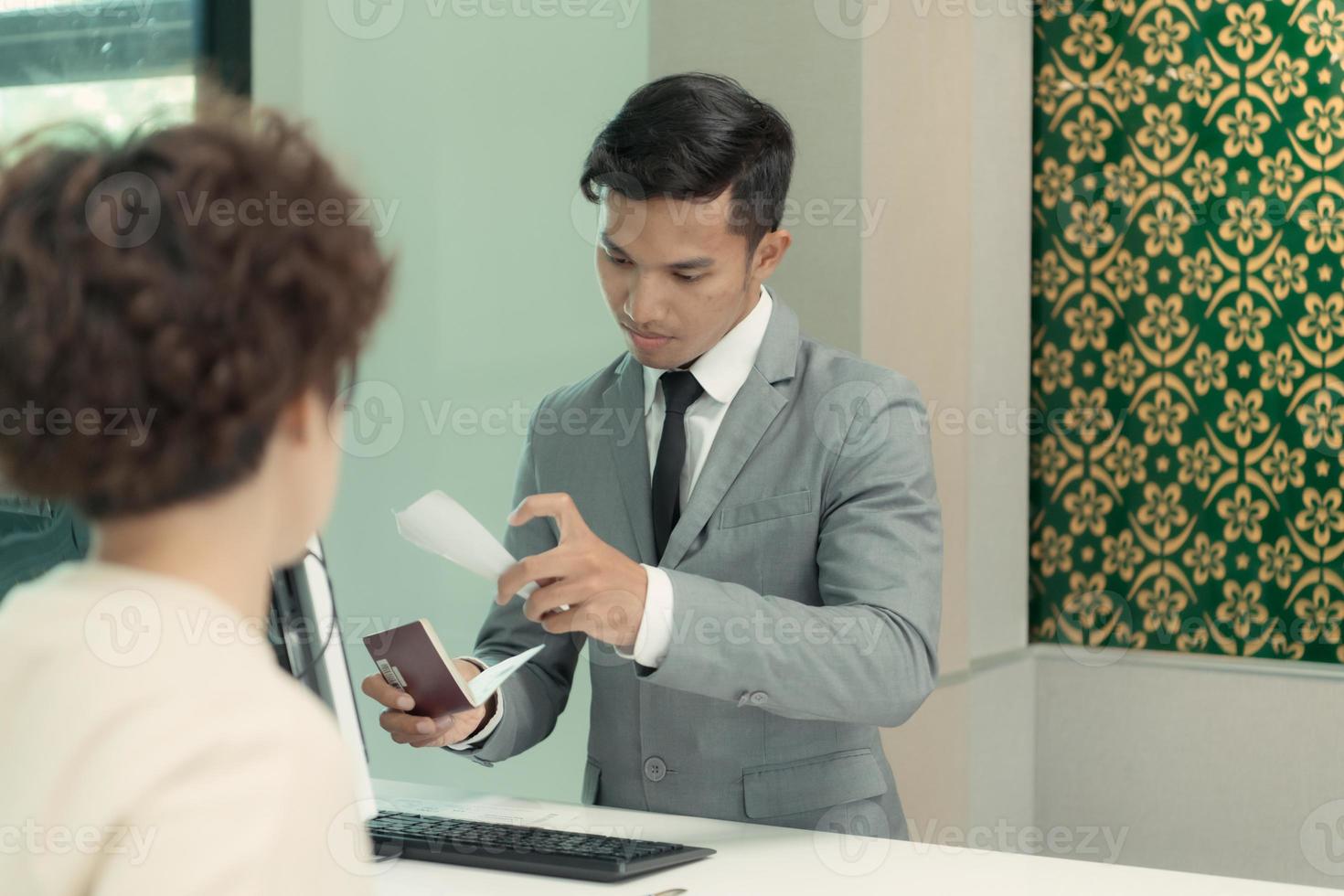 vliegmaatschappij grond personeel helpen passagiers controleren hun kaartjes en paspoorten voor reizen. foto