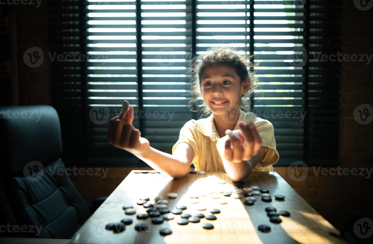 portret van een weinig meisje in kantoor kamer van huis met een spel van Gaan wezen geleerd naar bouwen concentratie en intelligentie. foto