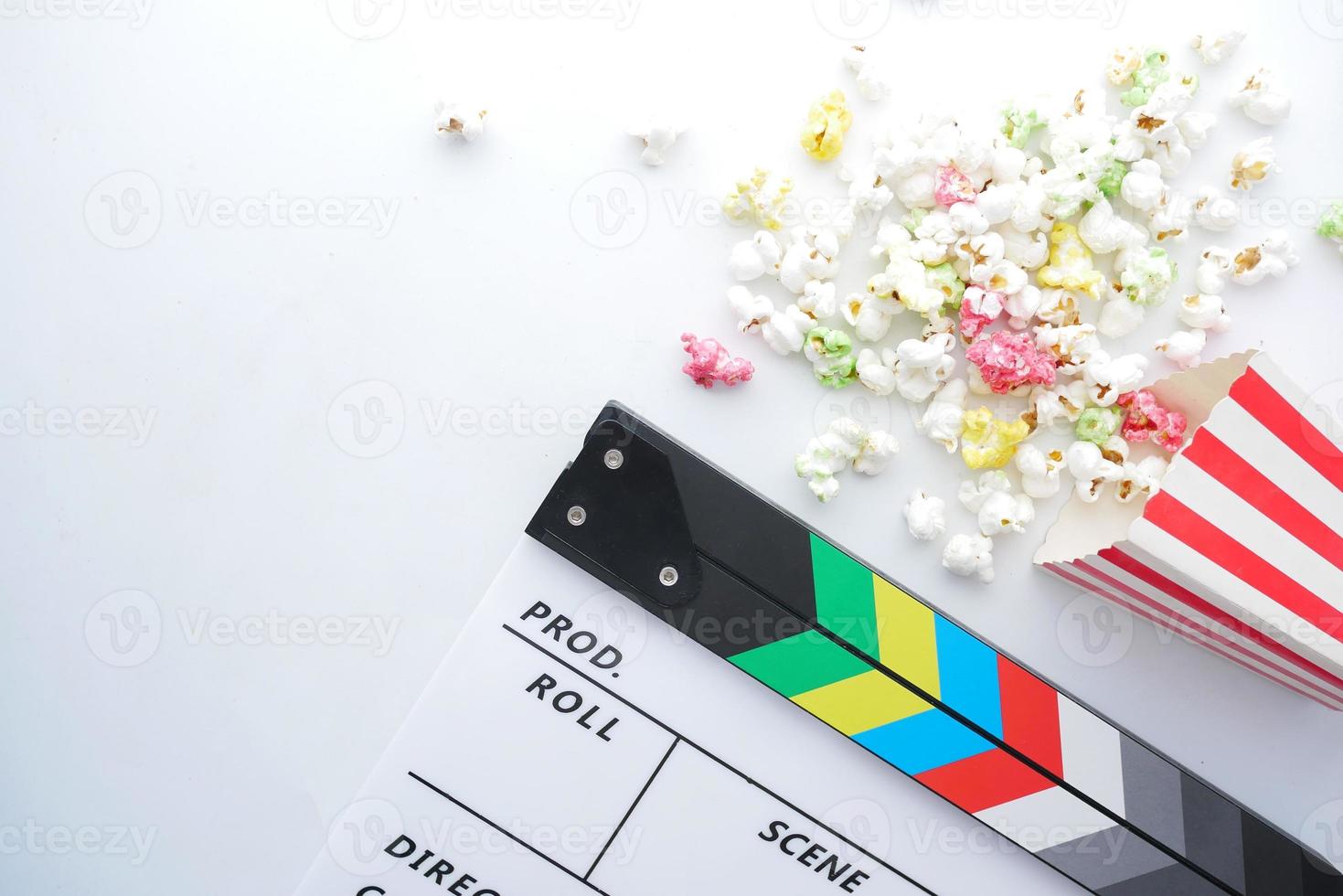 film klepel bord en popcorn op witte achtergrond foto