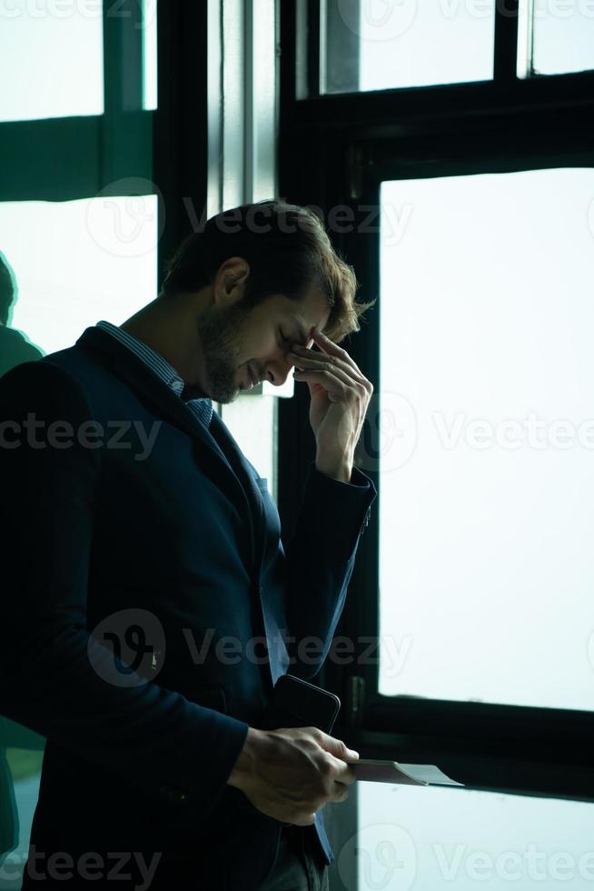 zakenman met emoties terwijl aan het wachten voor een lang reis Bij de luchthaven terminal foto