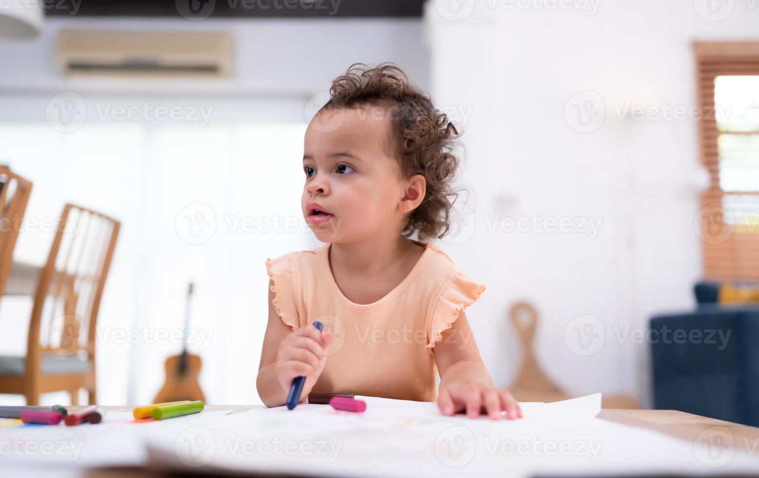 een weinig kind verbeelding is vertegenwoordigd door gekleurde potlood tekeningen, met de moeder aandachtig toezien op in de leven kamer van de huis. foto