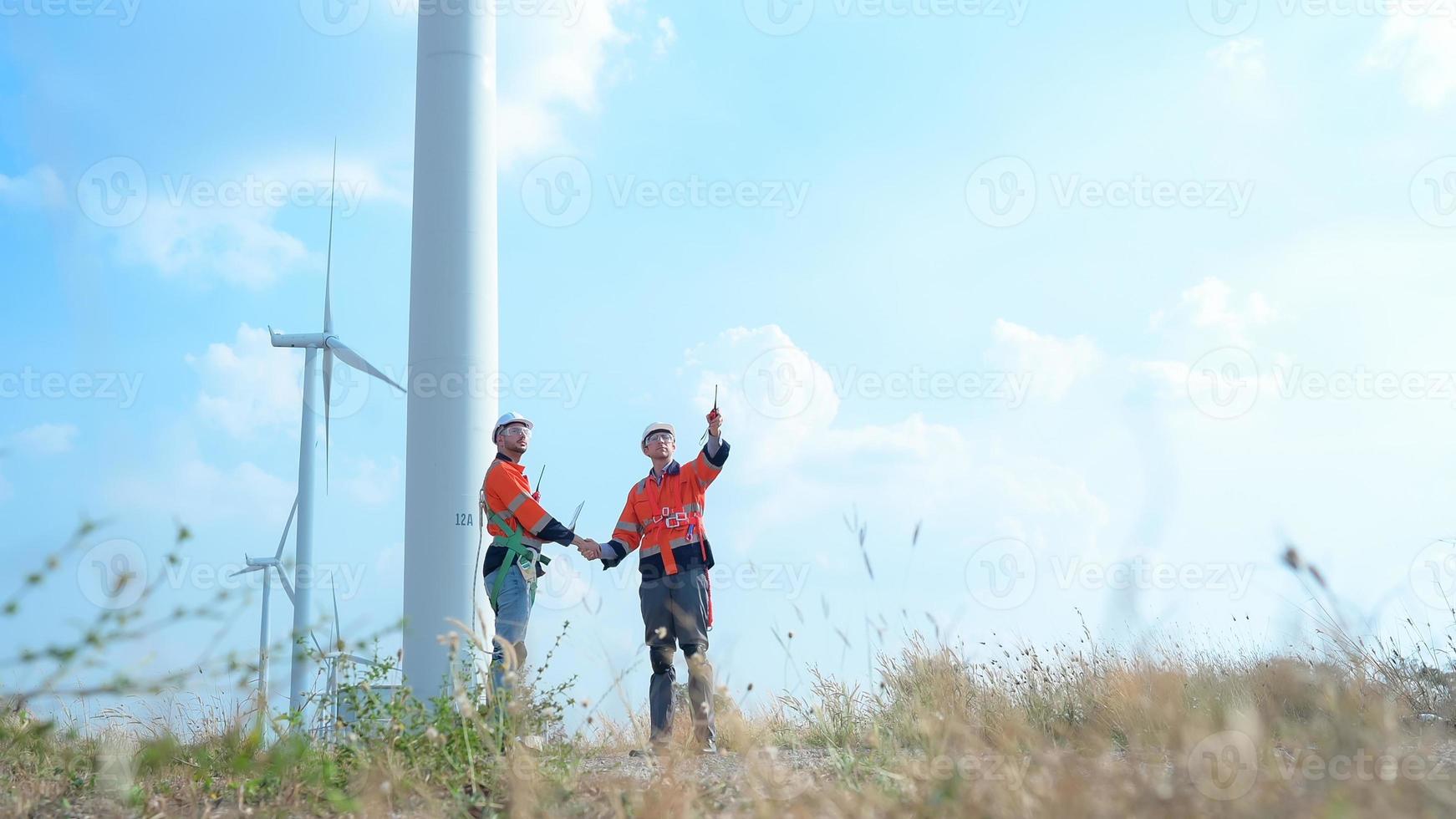 landmeter en ingenieur onderzoeken de rendement van gigantisch wind turbines dat transformeren wind energie in elektrisch energie dat is vervolgens gebruikt in dagelijks leven. foto