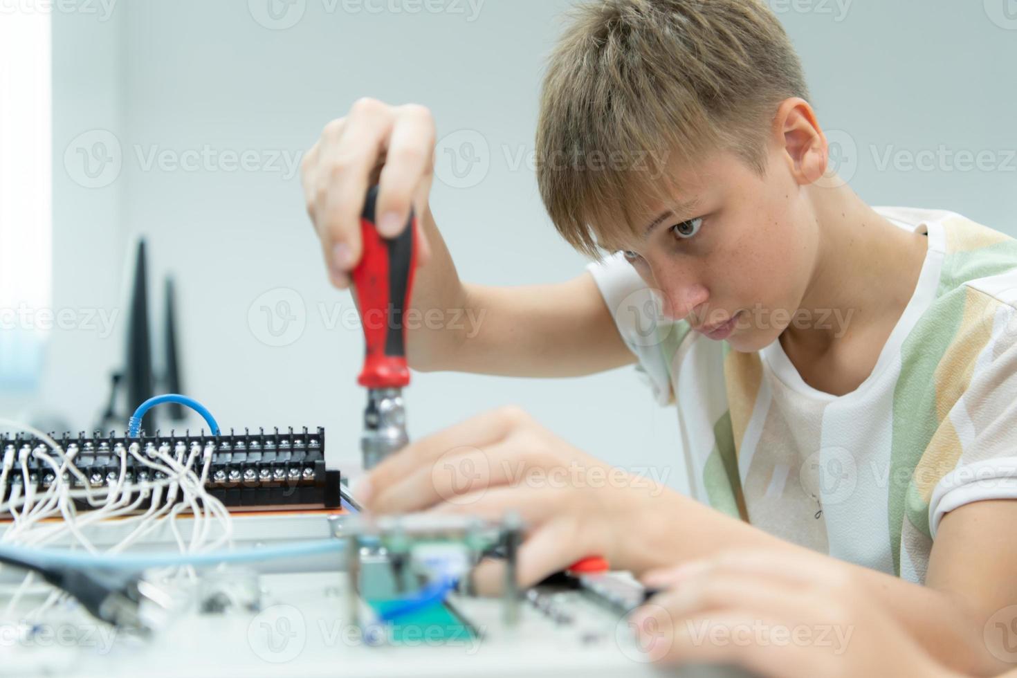 jongeren gebruik maken van de hand- robot technologie zijn hebben pret aan het leren de elektronisch stroomkring bord en hand- robot controleur van robot technologie, welke is een van de stam cursussen. foto