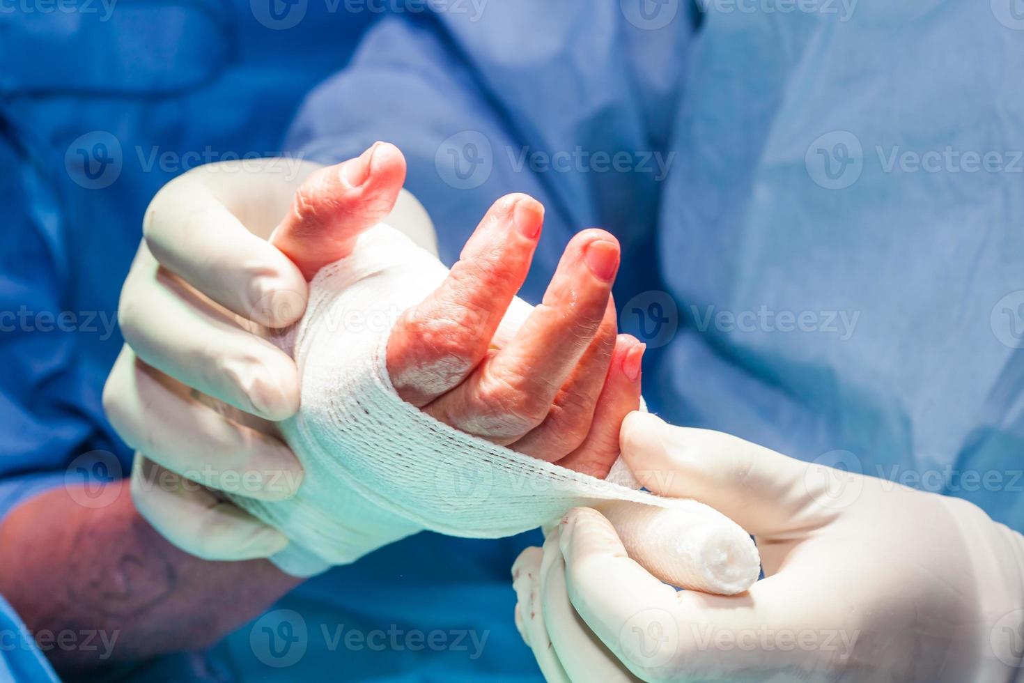 chirurg verband de hand- van een geduldig Bij de einde van chirurgie foto