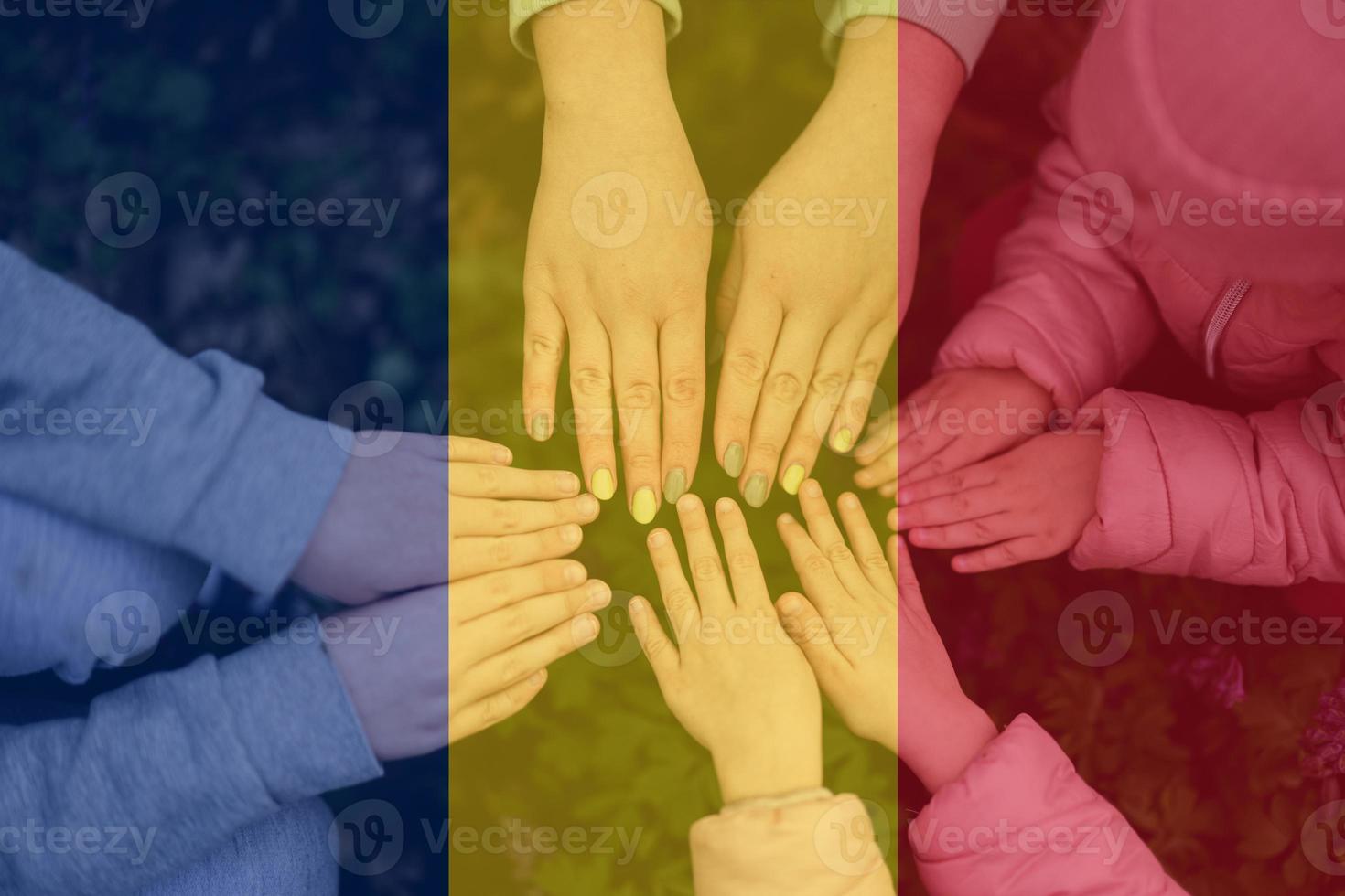 handen van kinderen Aan achtergrond van Roemenië vlag. Roemeense patriottisme en eenheid concept. foto