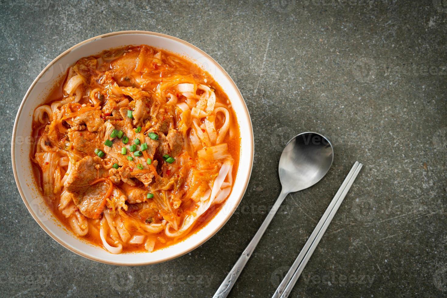 Koreaanse udon ramen-noedels met varkensvlees in kimchi-soep foto