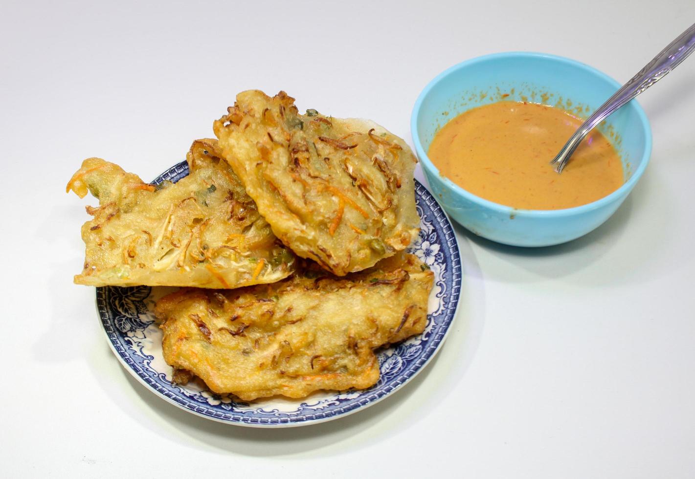 gebakken bakwan gevulde met groenten en pinda saus Aan een wit achtergrond foto