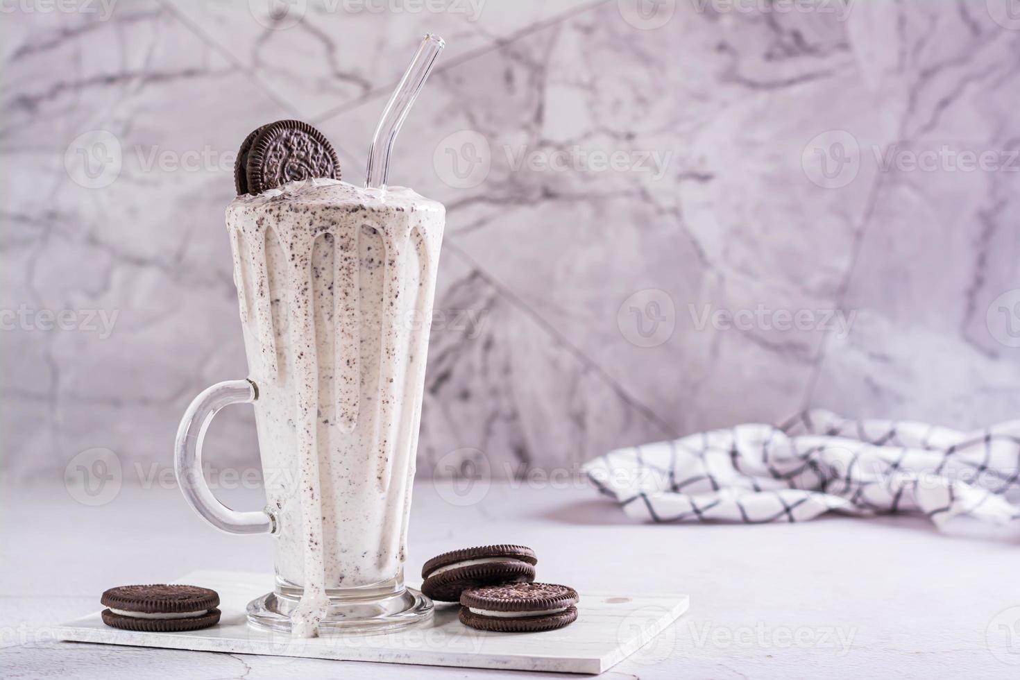 milkshake van chocola oreo koekjes en ijs room in een glas met een rietje foto
