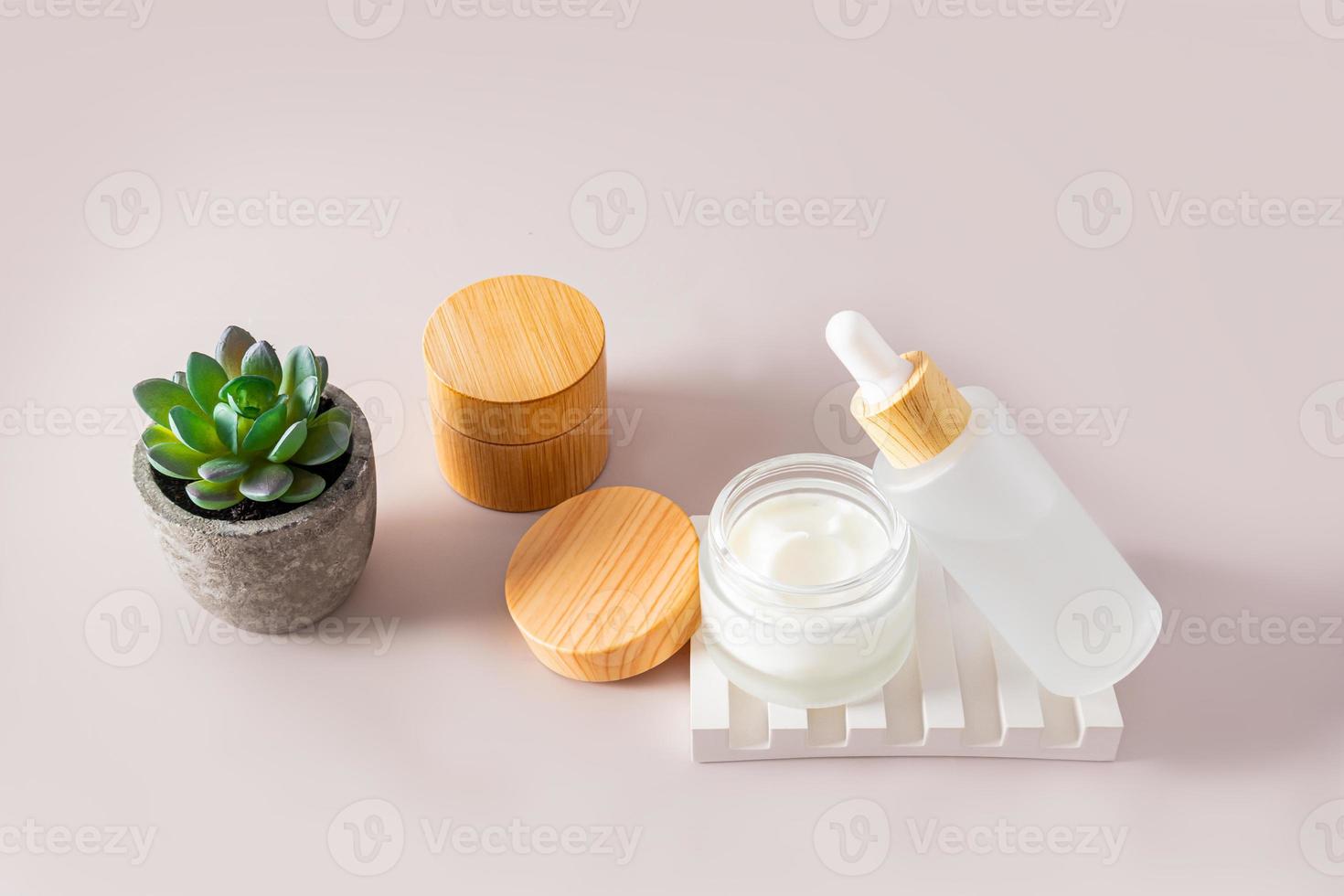 verjongend room en serum voor gezicht en lichaam huid zorg in kunstmatig containers Aan een pastel achtergrond. natuurlijk cosmetica. foto