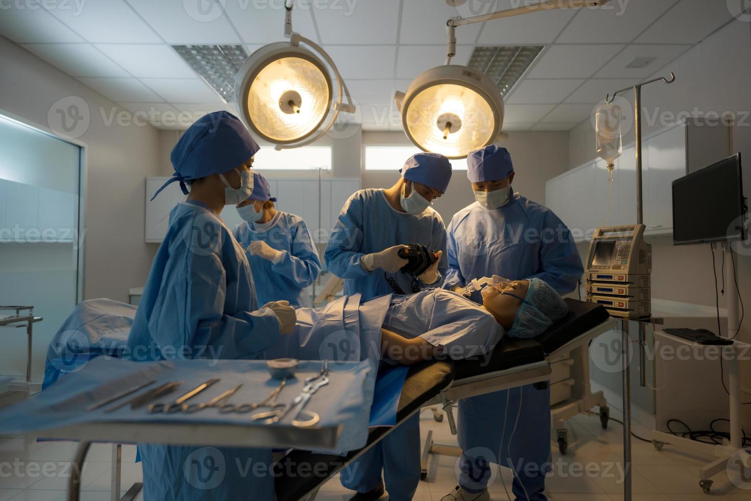 dokter, verpleegster aan het doen chirurgie Aan geduldig. foto