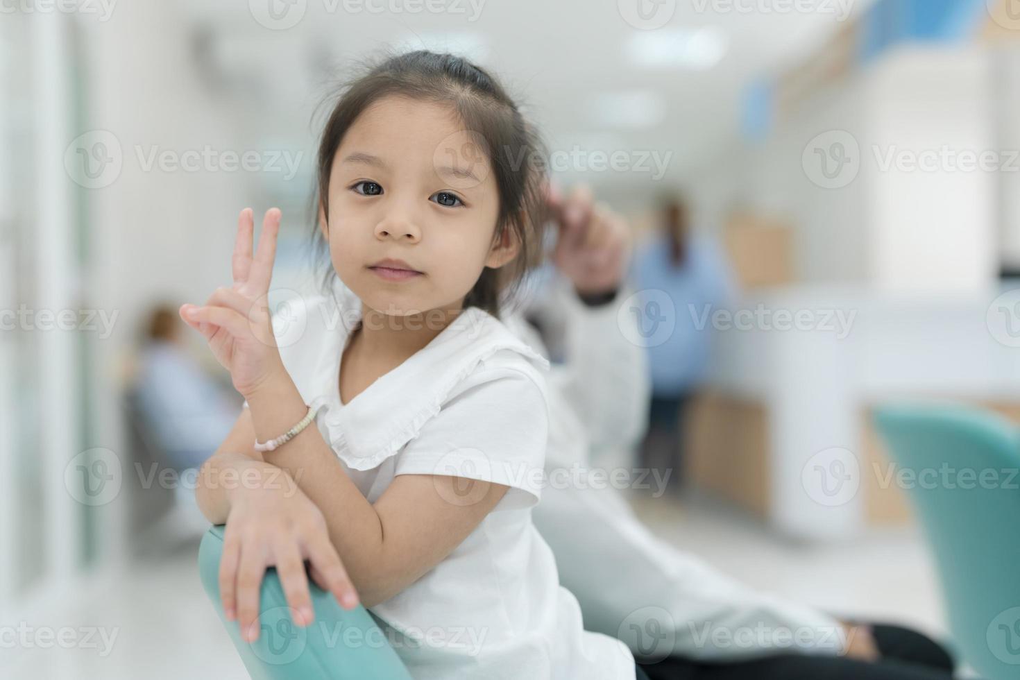 meisje zittend glimlachen in de ziekenhuis lobby. foto