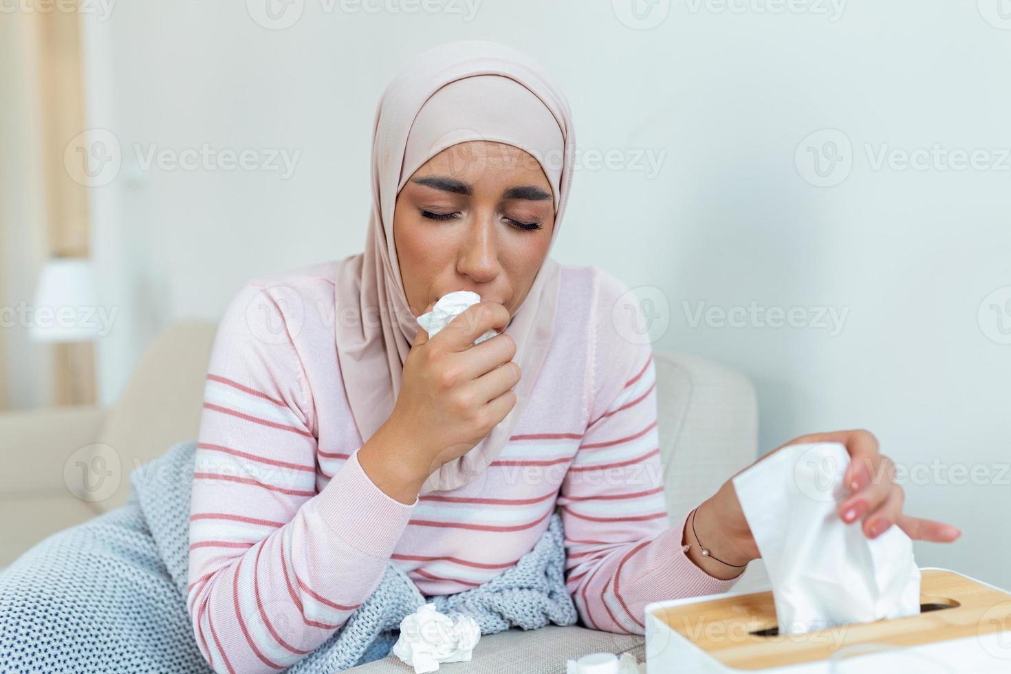 ziekte, seizoensgebonden virus probleem concept. Arabisch vrouw wezen ziek hebben griep aan het liegen Aan bank. ziek vrouw met hijab aan het liegen in bed met hoog koorts. verkoudheid griep coronavirus, covid19 foto