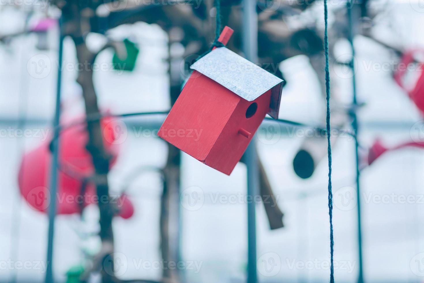 rood houten vogelhuisje hangende Aan de draad foto