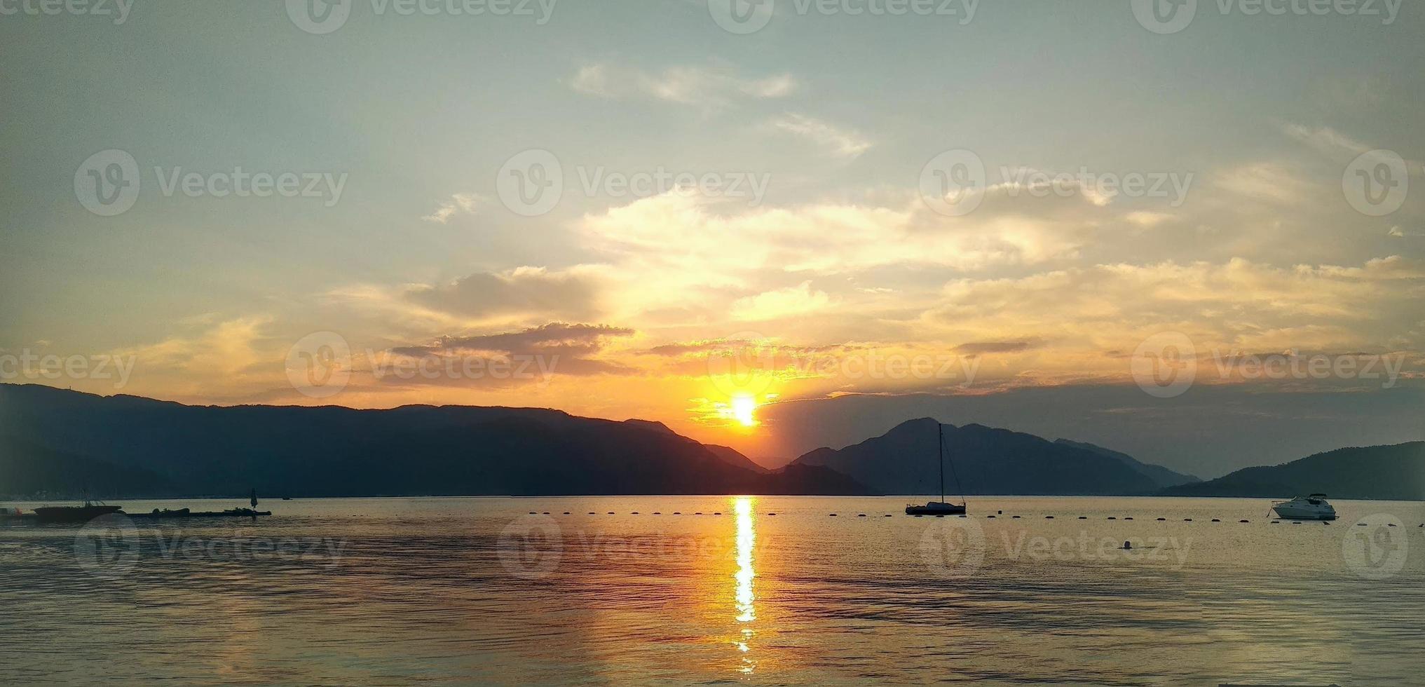 mooi zonsondergang Aan de zee en bergen foto