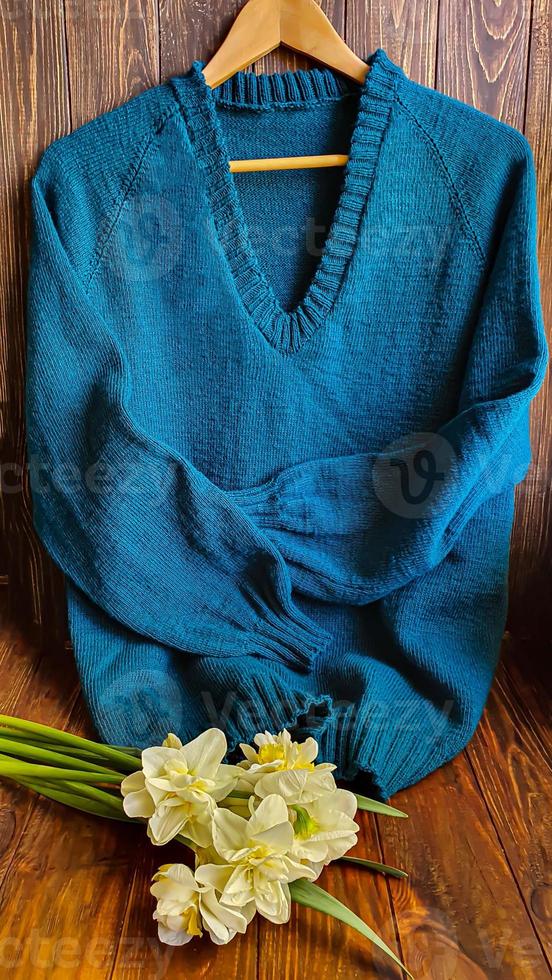 gebreid handgemaakt producten. gebreid kleding stof van gekleurde draden in de kleur van benzine. bruin achtergrond. foto