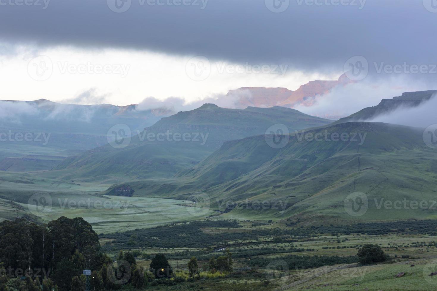 eerste stralen van zonlicht van de dag schijnen door de de nevel Aan de berg foto