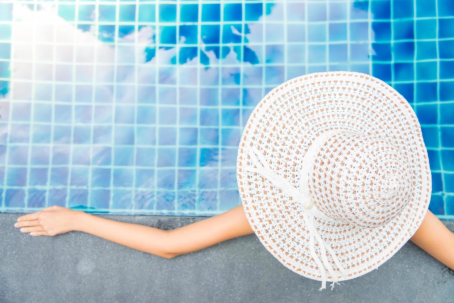 vrouwen dragen hoed in het zwembad van het hotel foto