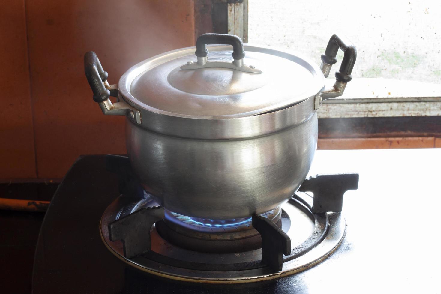 Koken met aluminium pot Aan de gas- fornuis in de keuken met vlam en rook. foto