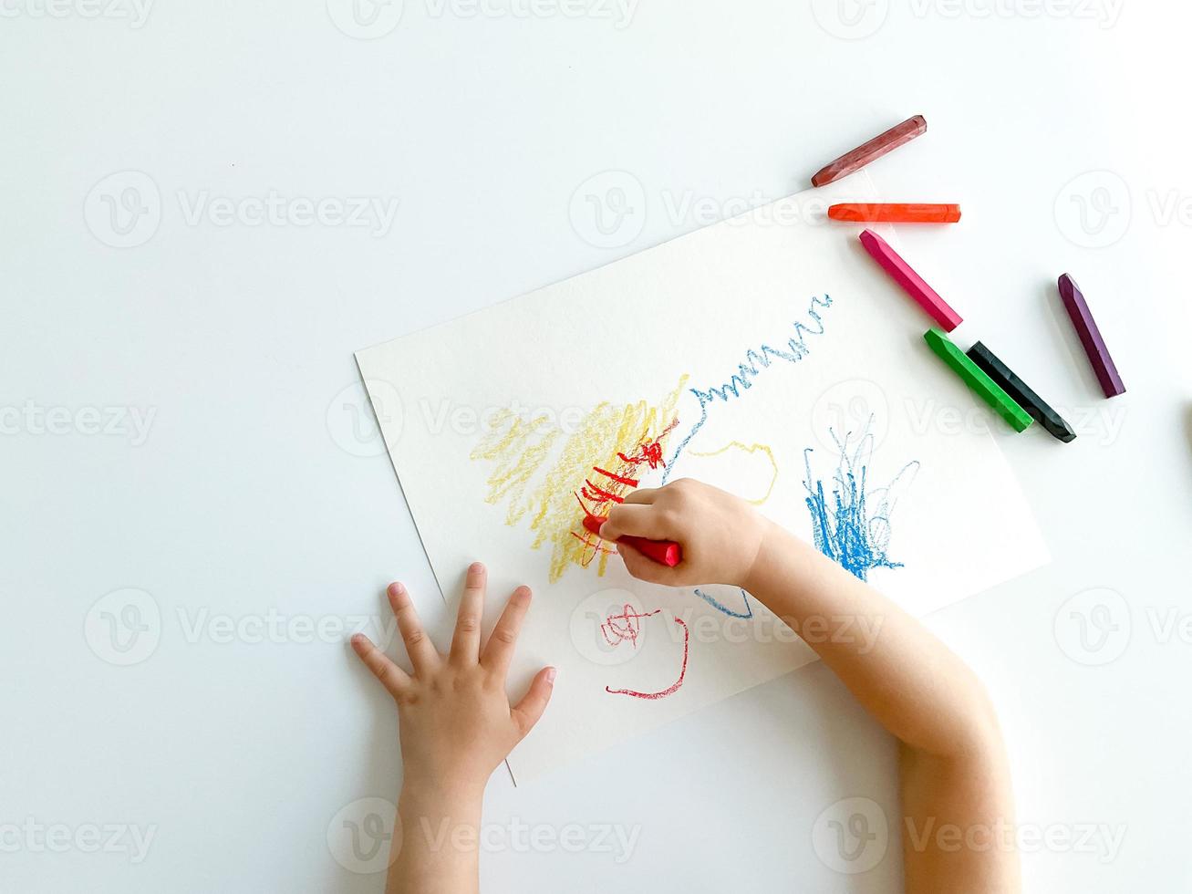 klein kind trekt met pastel kleurpotloden Aan wit tafel. vaders dag foto