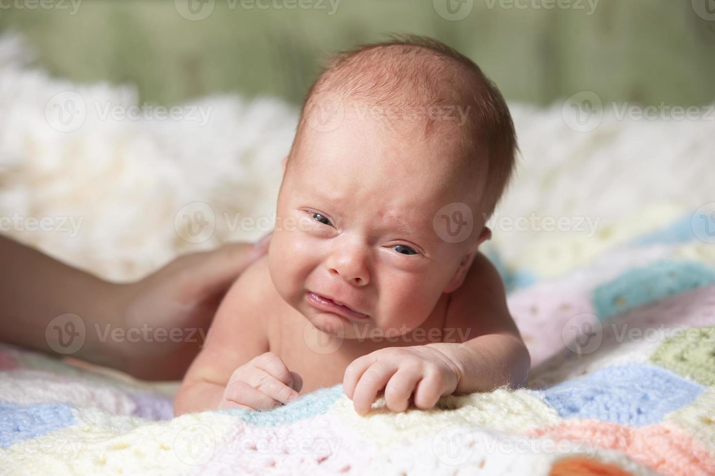 pasgeboren baby met grappig gezicht. weinig baby huilen. baby Holding haar hoofd foto