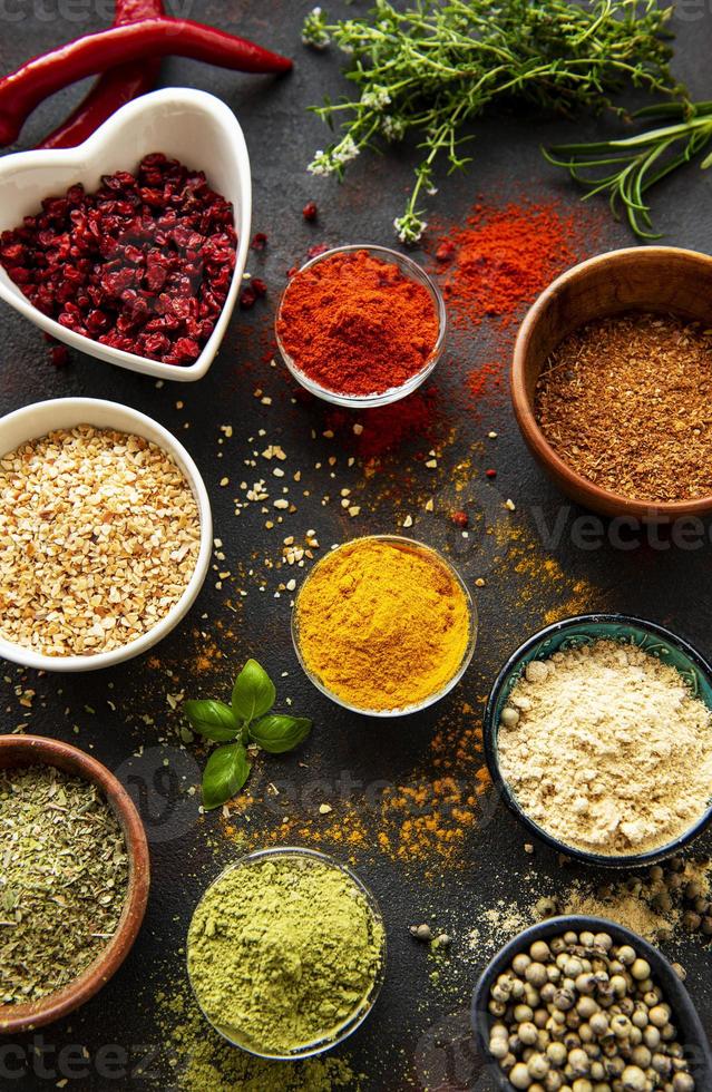 kleurrijke en aromatische kruiden en specerijen op een donkere achtergrond foto