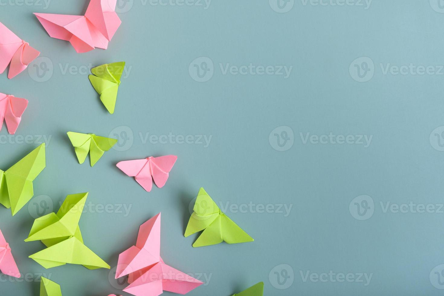 papier vlinders groen en roze kleur vlak leggen Aan een gekleurde achtergrond. lichtheid, voorjaar schoonheid concept foto