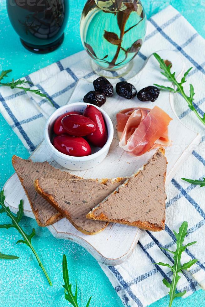 gegrild belegd broodje met paté met kip lever en olijven Aan blauw achtergrond foto