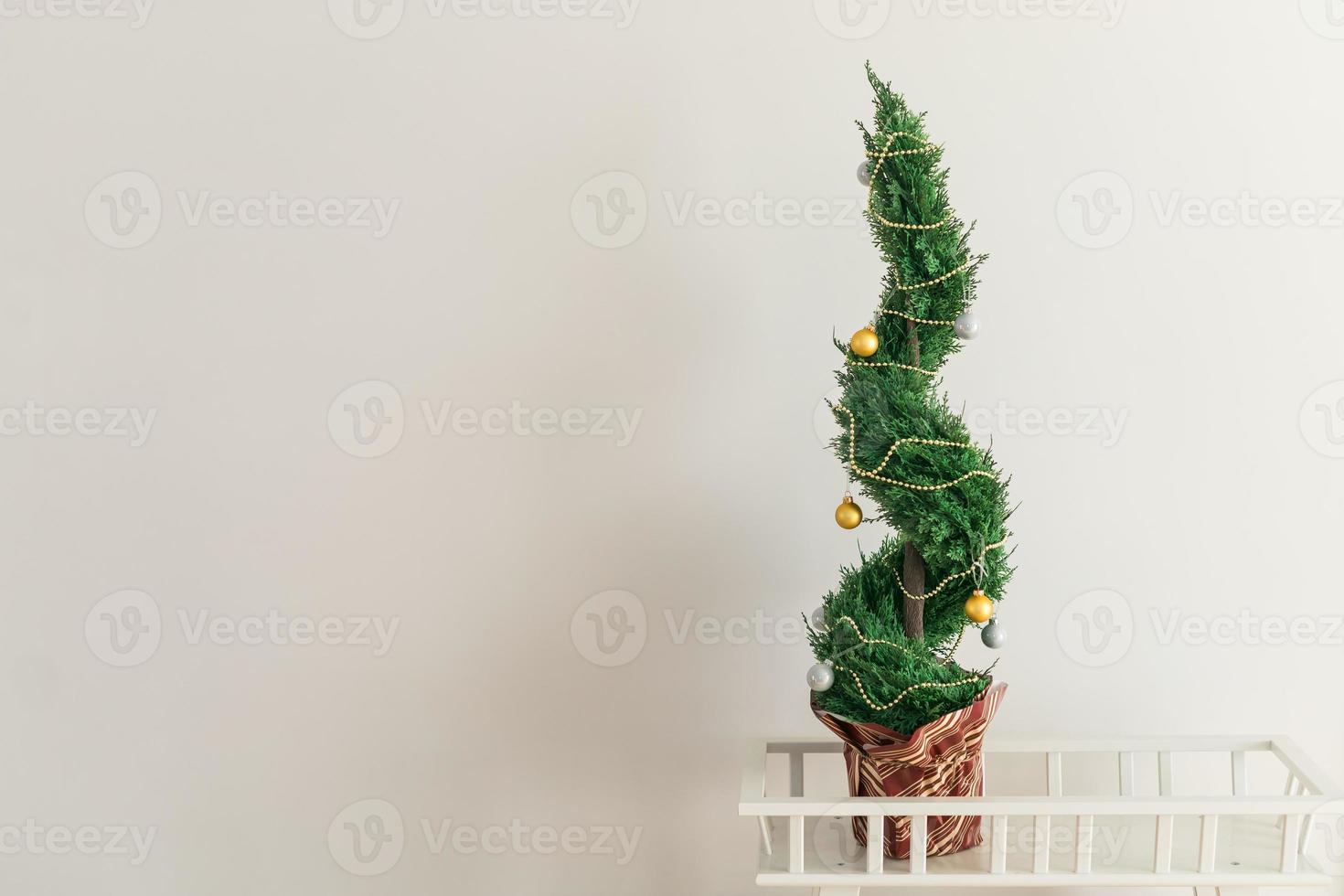 binnen- cipres of thuja in pot is decoreren ballen Leuk vinden Kerstmis boom. alternatief bomen voor Kerstmis . kopiëren ruimte en ruimte voor reclame foto