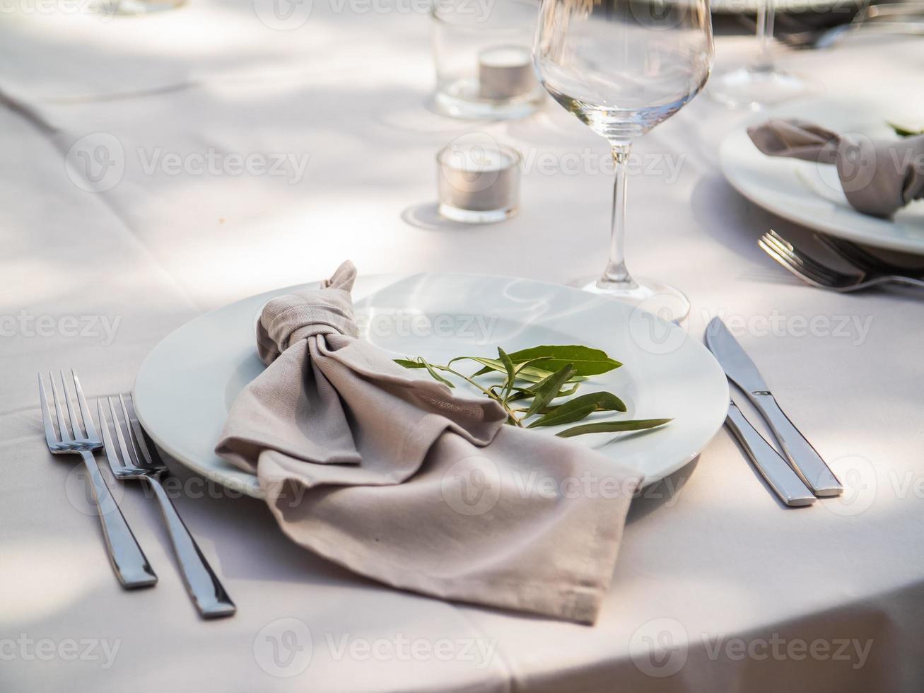 mooi buitenshuis bruiloft decoratie in stad. kaarsen en droog bloemen en accessoires met boeketten en bril Aan tafel met linnen tafelkleed Aan pasgetrouwde tafel Aan groen gazon foto