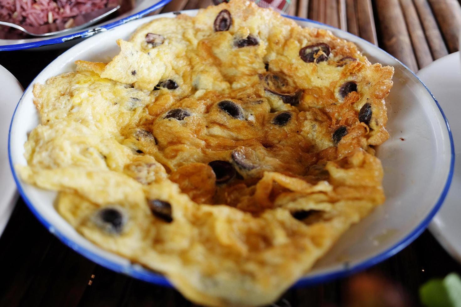 Thais stijl varkensvlees omelet met bladerdeeg bal champignons in wit bord foto