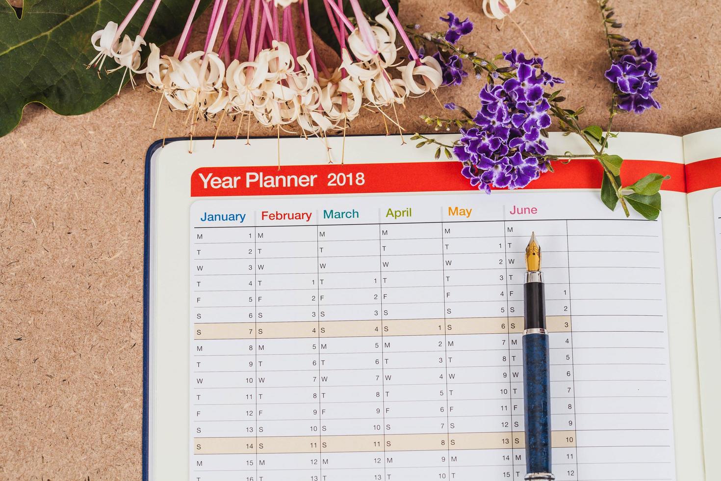 persoonlijk organisator of ontwerper met fontein pen Aan hout tafel. foto