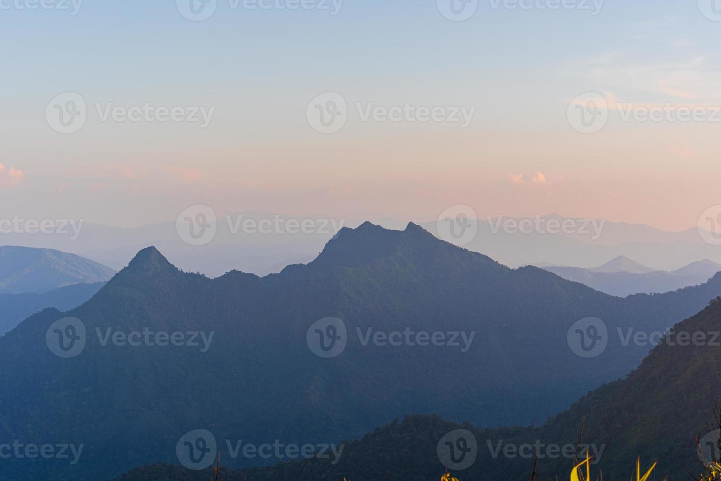 hoge hoek gezichtspunt zonsondergang over bergen en bos foto