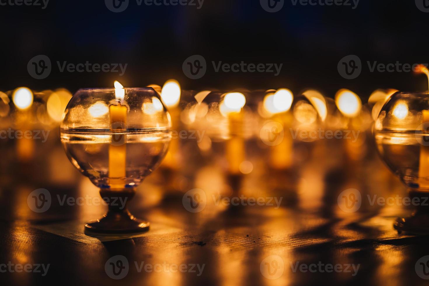 kaarsen in glas op de vloer ingericht voor gebedsceremonie in de kerk foto