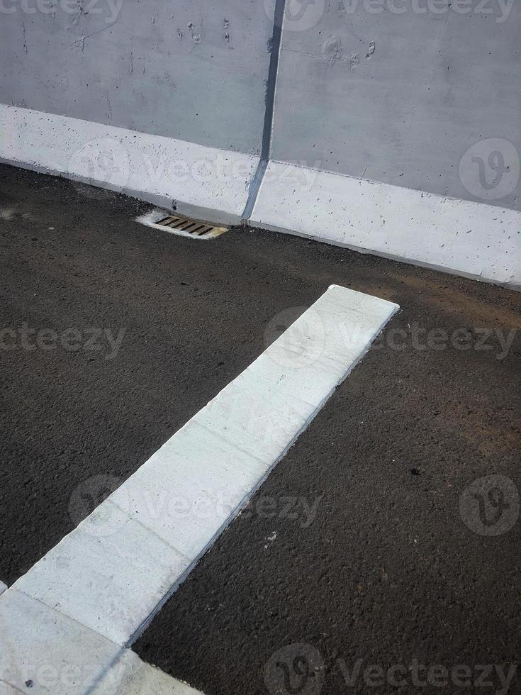 een wit markering Aan een nieuw snelweg. deze is een van de gerommel strip markeringen geïnstalleerd voordat de tol poort naar langzaam naar beneden de snelheid van voertuigen foto