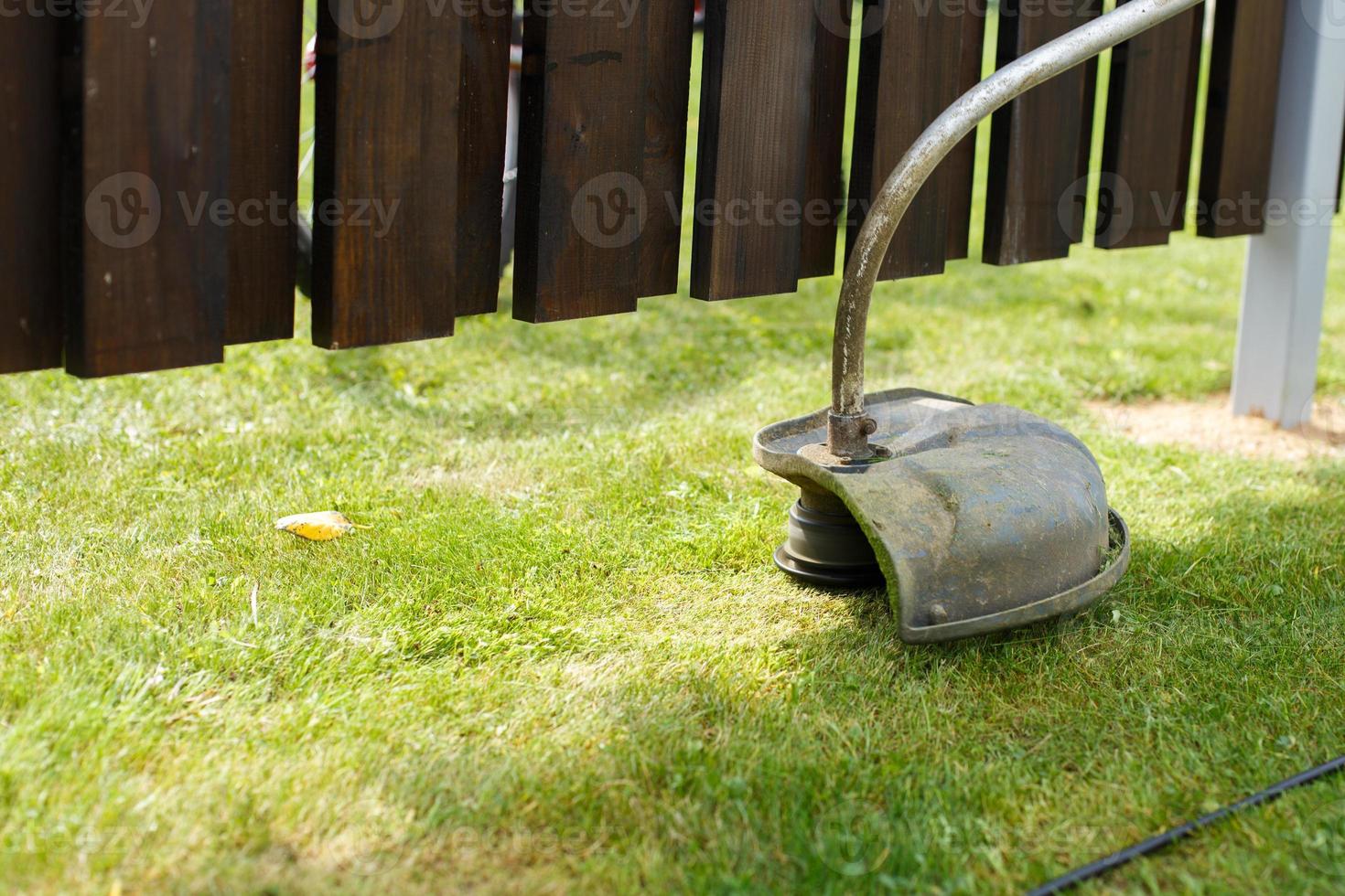 een Mens maait gras met een trimmer buitenshuis foto