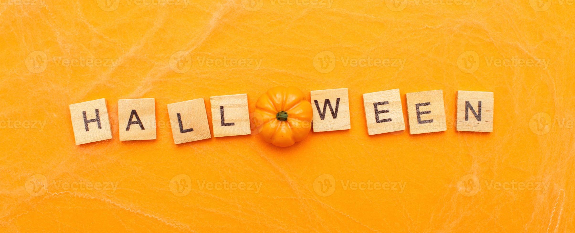 de opschrift halloween uitverkoop met weinig pompoen Aan oranje achtergrond met spin web. banier foto