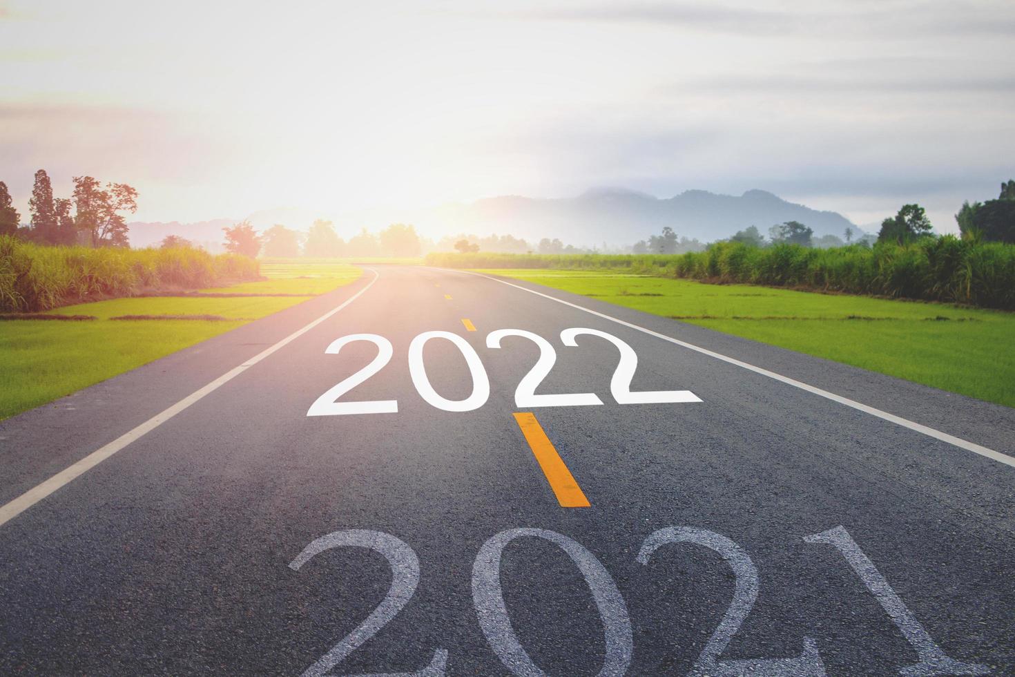 concept nieuwjaar met het woord 2021 tot 2022 geschreven op de asfaltweg foto