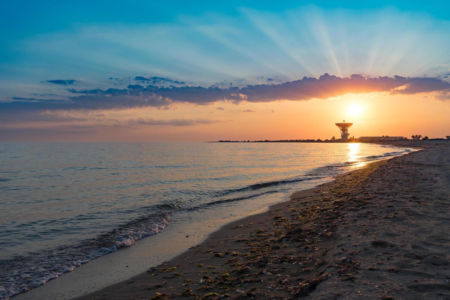 prachtige zonsondergang op de achtergrond van de zee en de ruimteantenne. foto