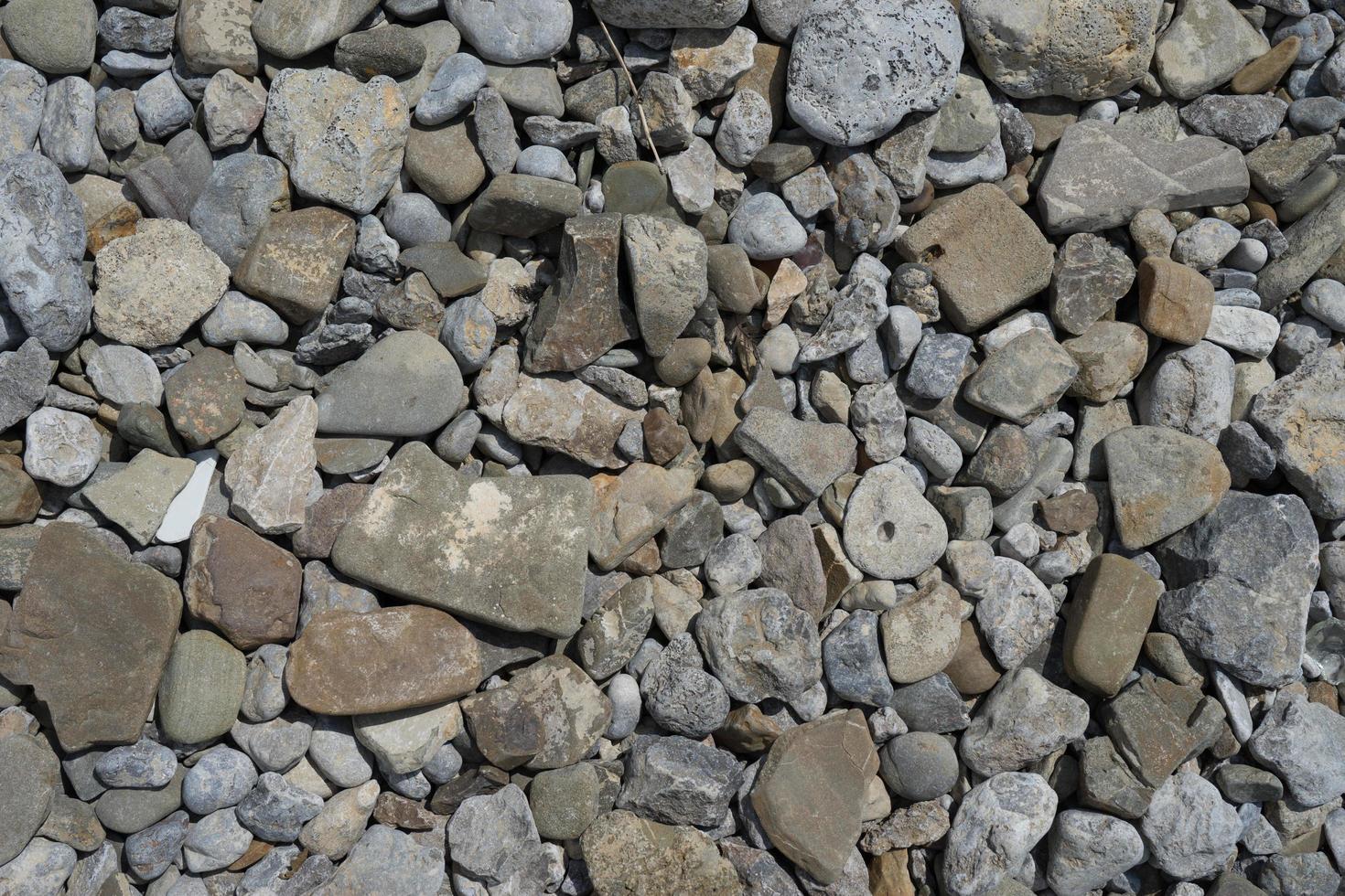 natuurlijke achtergrond van stenen van verschillende groottes van grijs. foto