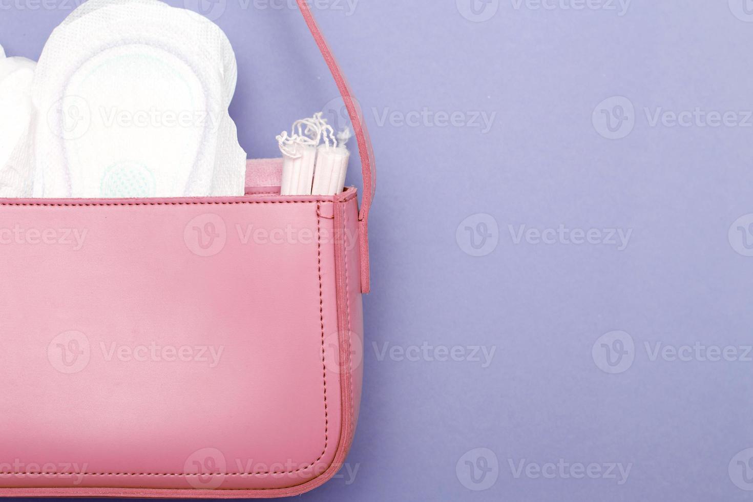 tampons, hygiënisch panty voeringen, vrouwelijk sanitair stootkussens in een vrouwen roze kunstmatig zak foto