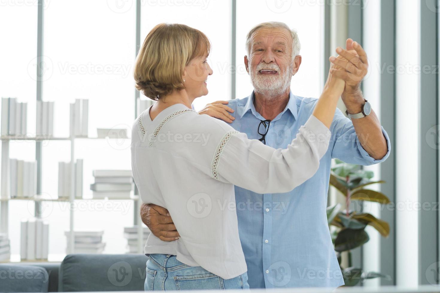 gelukkig senior paar familie, romantisch blanken volwassen, volwassen minnaar, gepensioneerd echtgenoot, vrouw hebben plezier, genieten van terwijl uitgeven tijd dansen samen in leven kamer Bij huis. glimlachen ouderen Mens, vrouw. foto