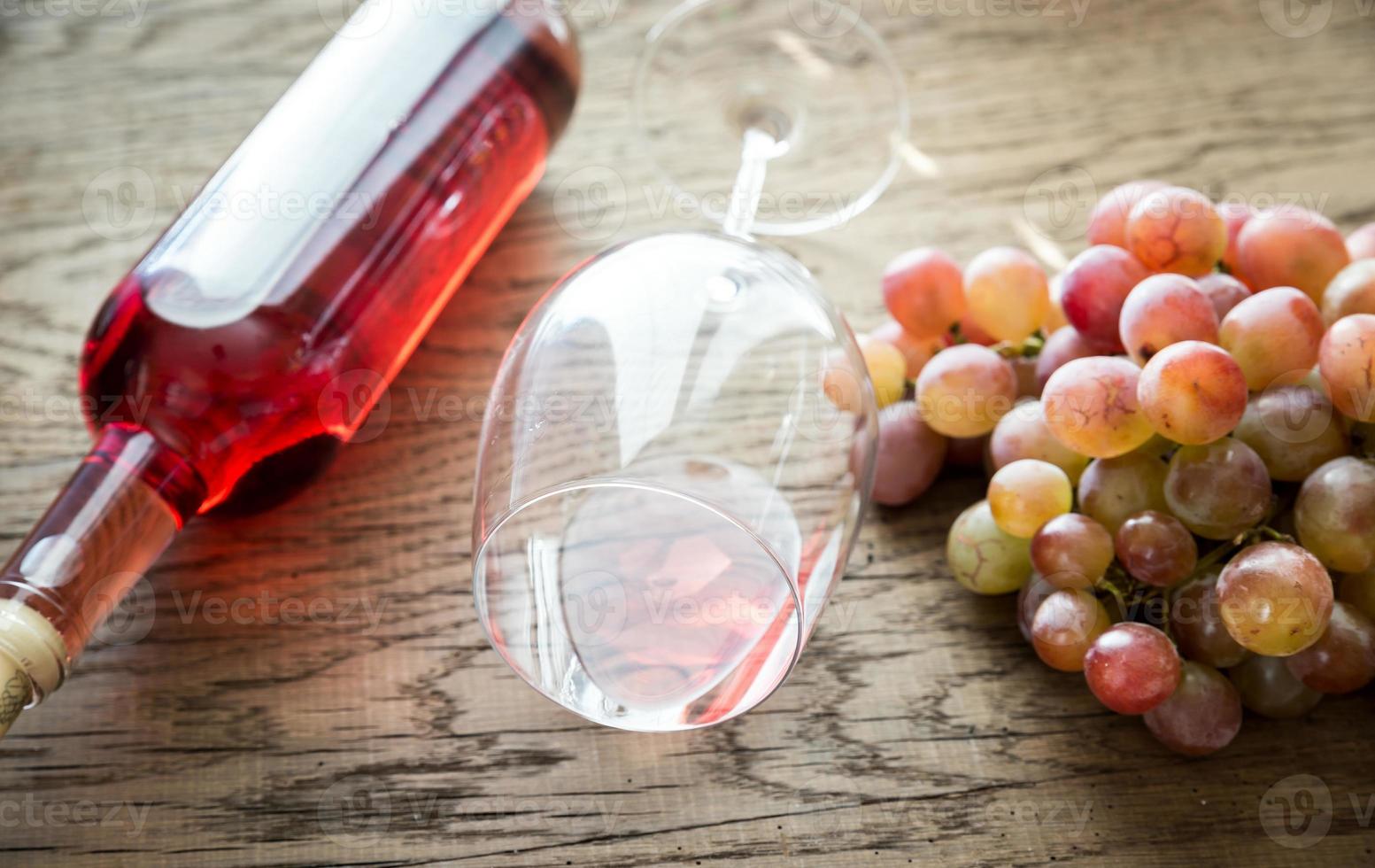 glas van roos wijn met bundel van druif foto