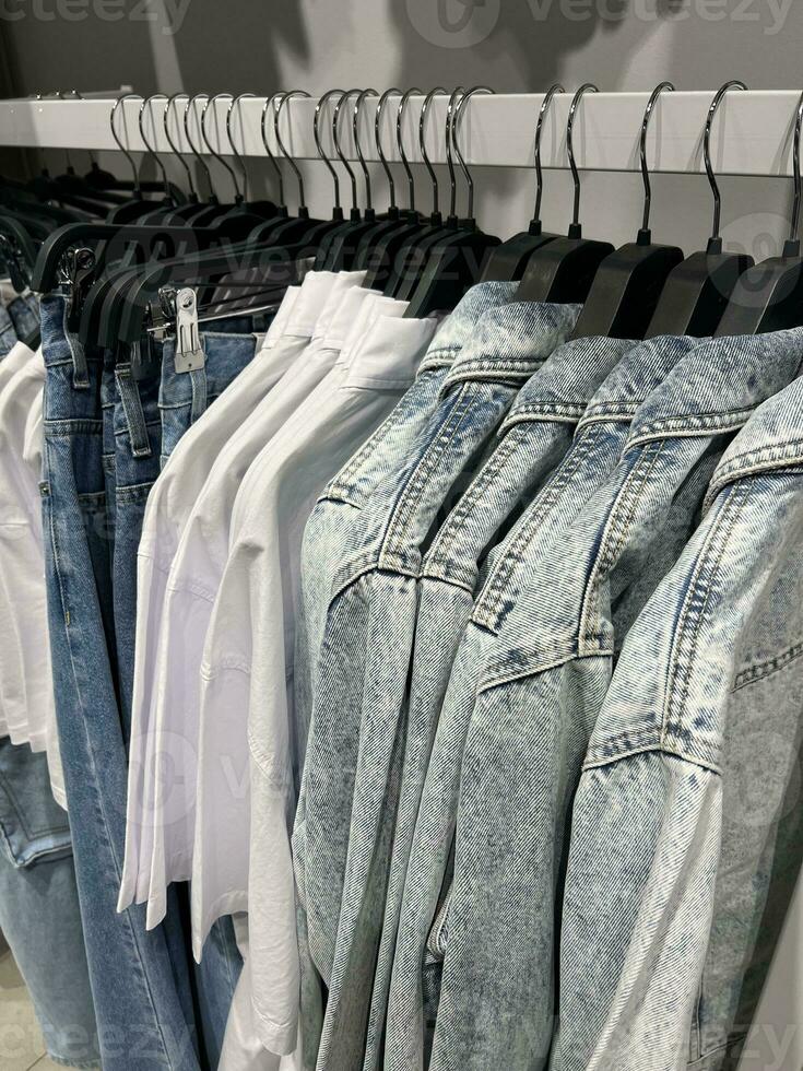 op te slaan kleren Aan hangers. groot assortiment van kleurrijk kleren. foto