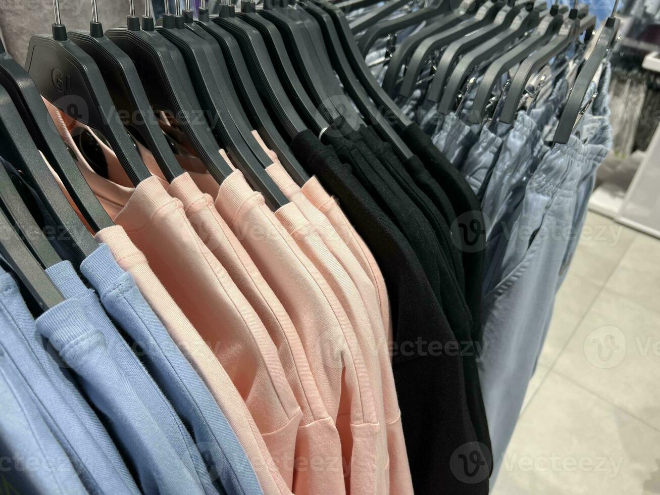 op te slaan kleren Aan hangers. groot assortiment van kleurrijk kleren. foto