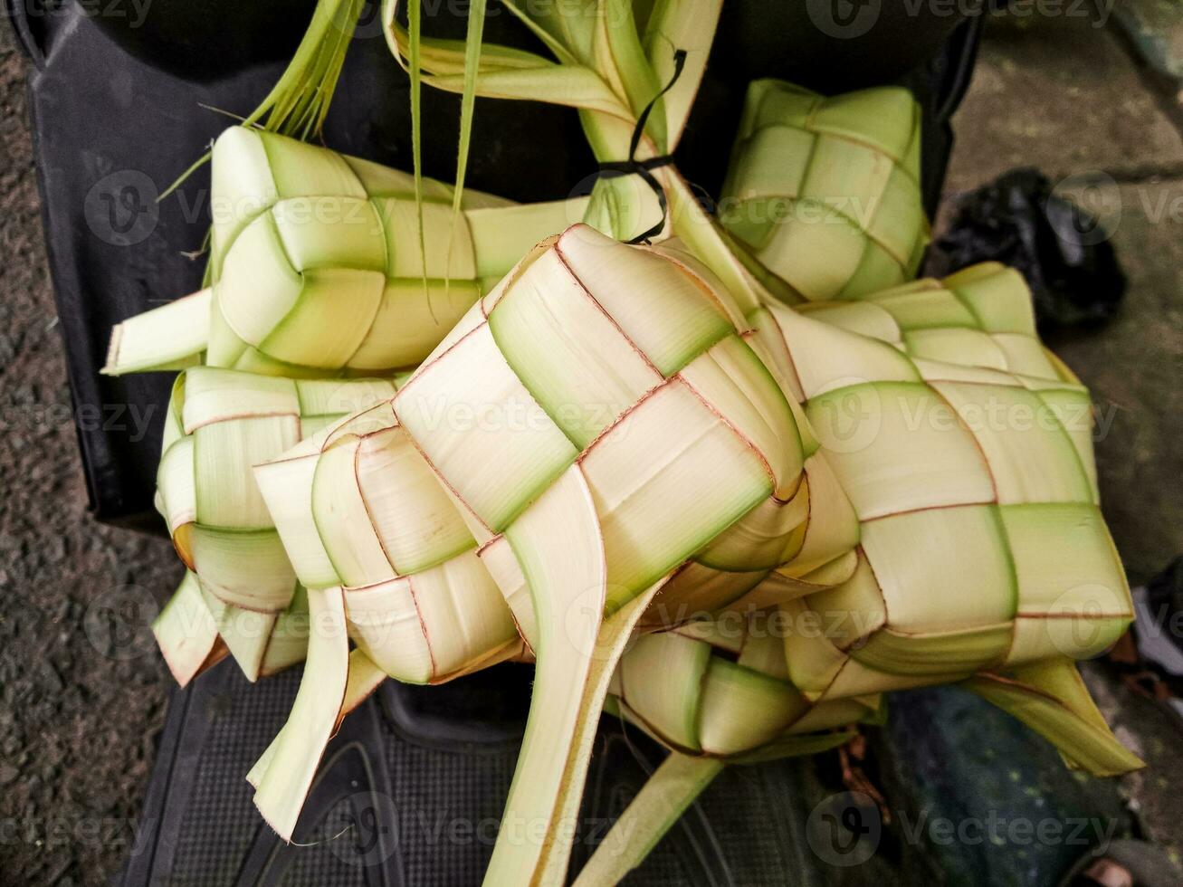 ketupat of een bundel van bamboe bladeren zijn gebonden samen met de woord palm. foto