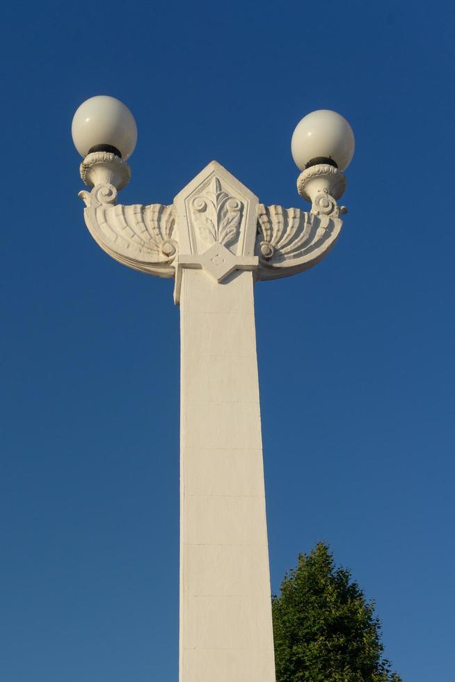 mooie witte stenen lantaarnpaal op de achtergrond van de blauwe hemel. foto