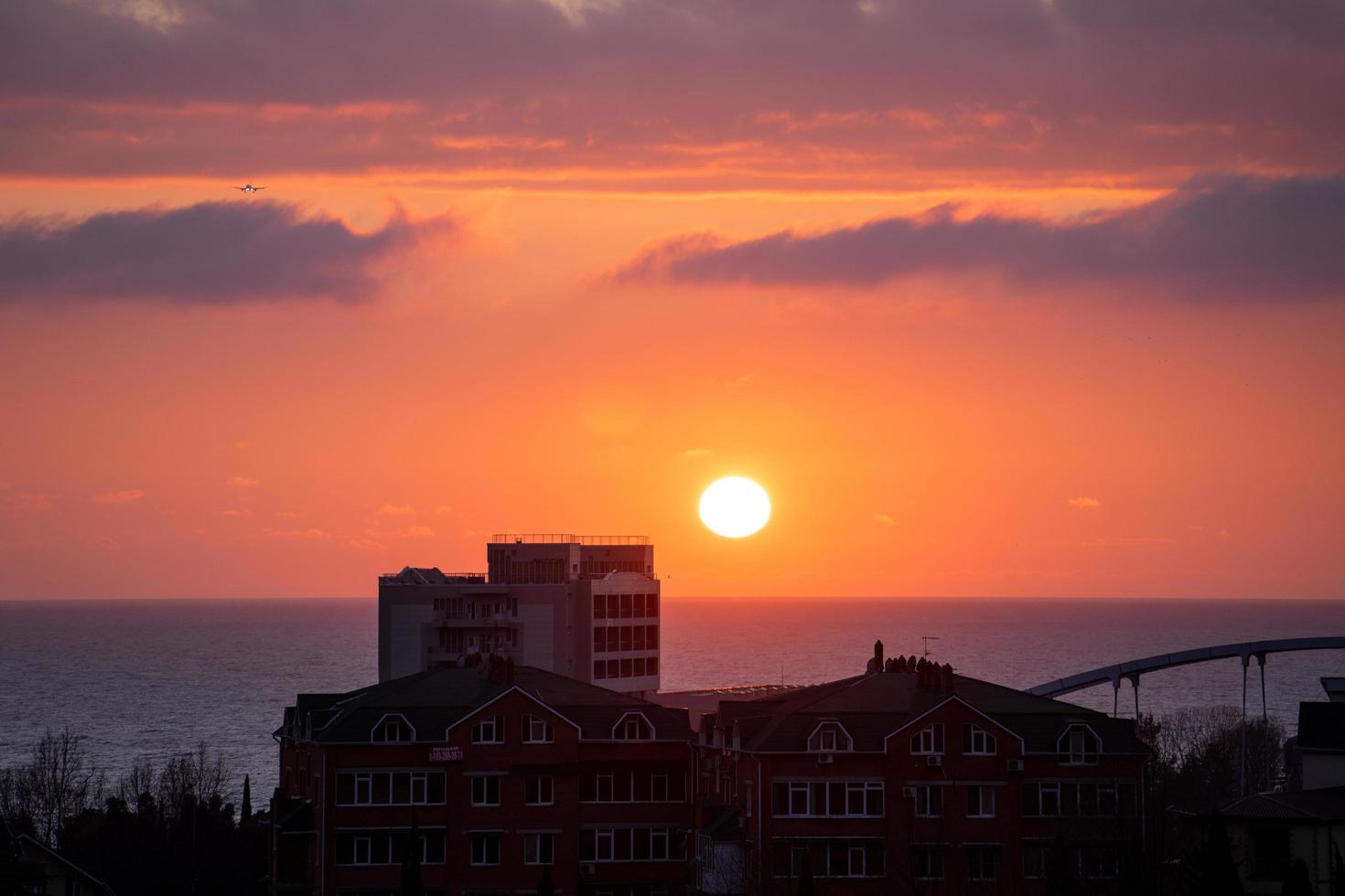 landschap met uitzicht op de zonsondergang over zee en stad foto