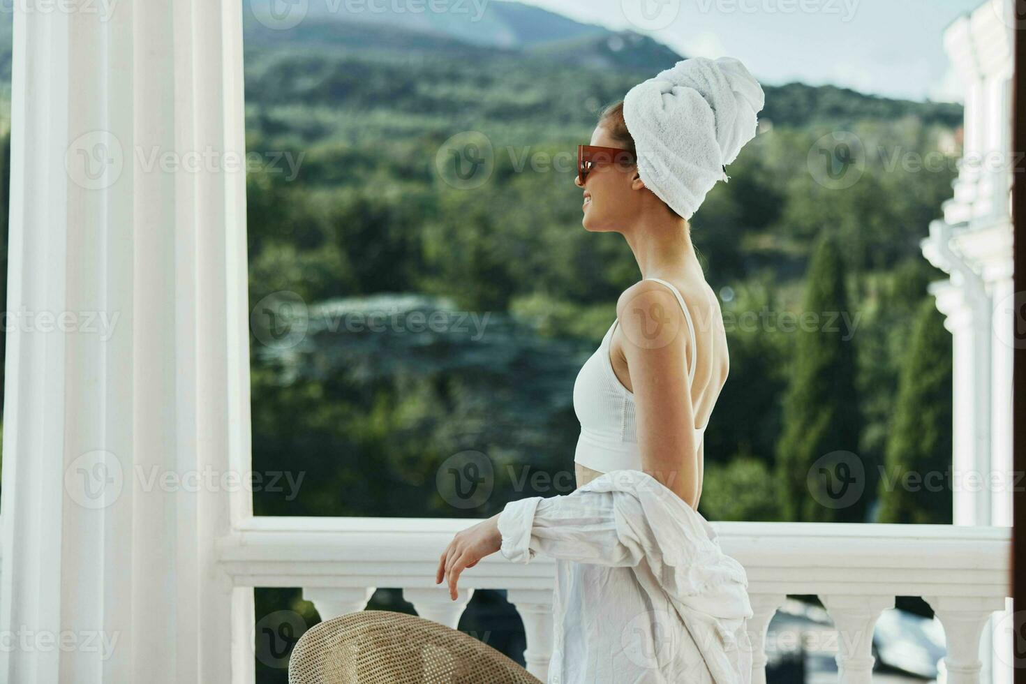 modieus vrouw in zonnebril Aan de balkon resting in de ochtend- foto